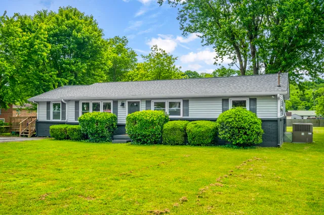 a view of a house with a yard and sitting area