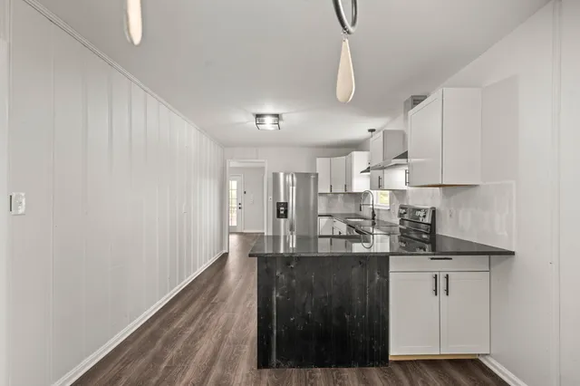 a kitchen with kitchen island granite countertop a sink cabinets and stainless steel appliances