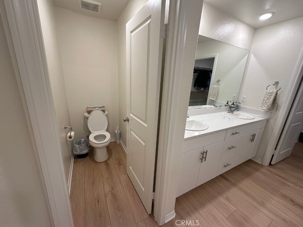 2511 Gunner Ridge Way Rialto, CA 92377 - Photo 21 of 37 a spacious bathroom with a double vanity sink a mirror and a toilet
