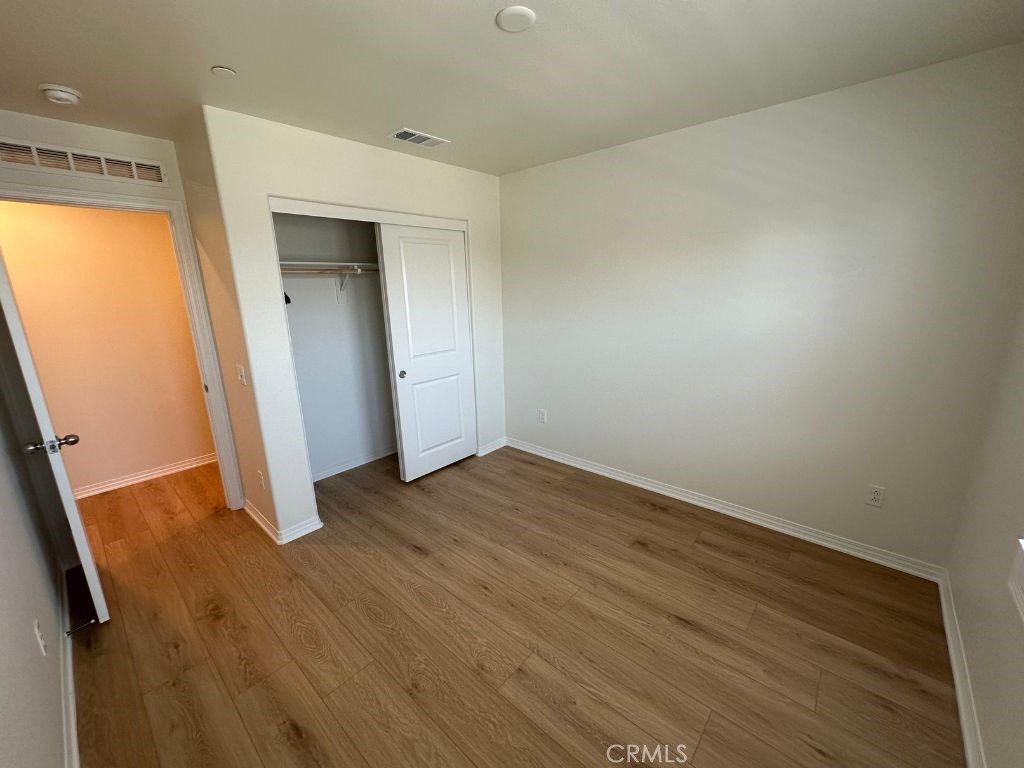 2511 Gunner Ridge Way Rialto, CA 92377 - Photo 24 of 37 an empty room with wooden floor and entrance