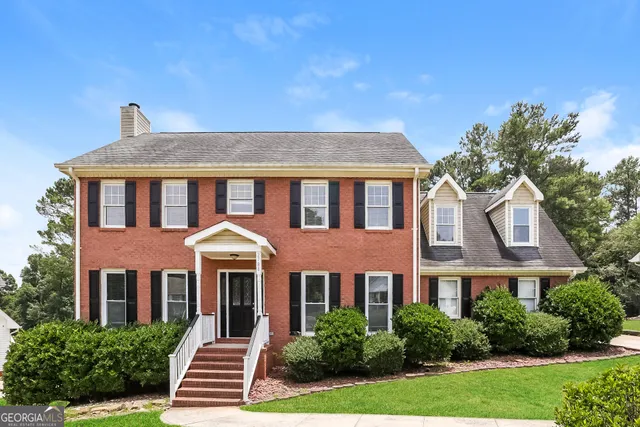 a front view of a residential houses with yard and green space