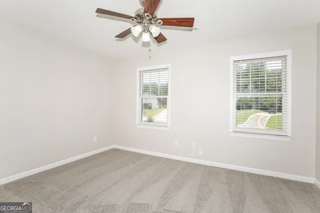 an empty room with a window and a fan