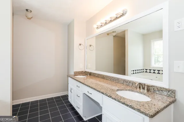 a bathroom with a granite countertop sink and a mirror