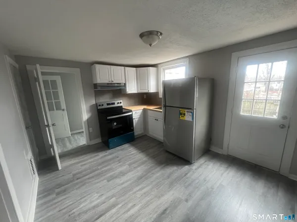 a kitchen with granite countertop a refrigerator and a sink