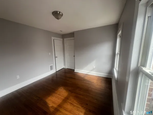 a view of empty room with wooden floor