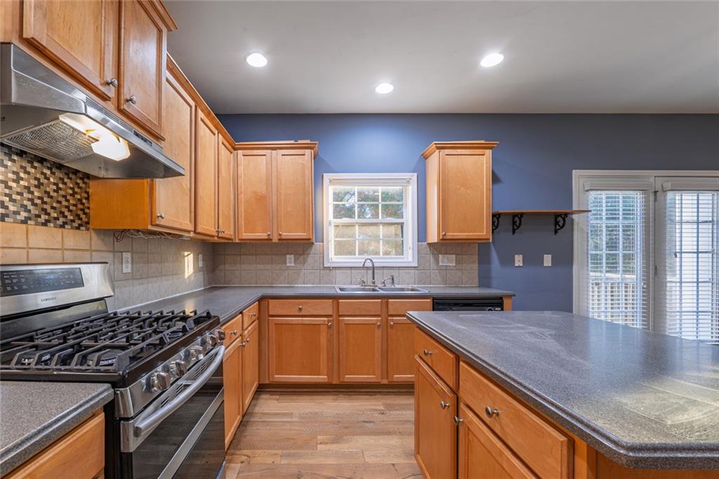 1280 Hidden Creek Point Cumming, GA 30040 - Photo 20 of 62 a kitchen with stainless steel appliances granite countertop a sink stove and cabinets
