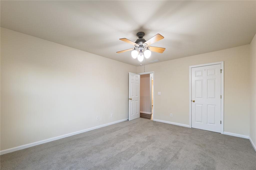 1280 Hidden Creek Point Cumming, GA 30040 - Photo 23 of 62 an empty room with chandelier fan and windows