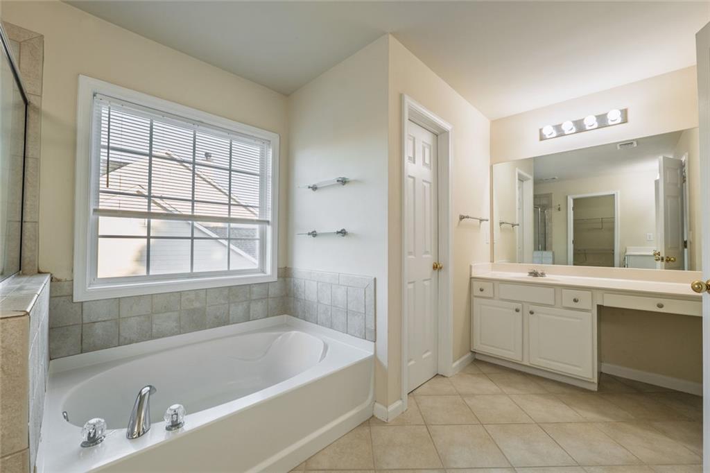 1280 Hidden Creek Point Cumming, GA 30040 - Photo 34 of 62 a bathroom with a tub a sink and a window