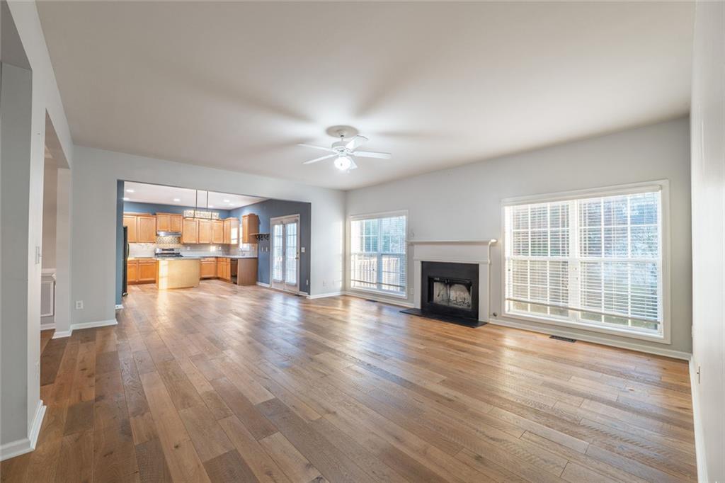 1280 Hidden Creek Point Cumming, GA 30040 - Photo 10 of 62 a view of a livingroom with wooden floor a fireplace and window