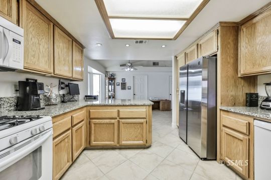 1260 Arroyo Street Ridgecrest, CA 93555 - Photo 8 of 44 a kitchen with stainless steel appliances granite countertop a refrigerator and a stove top oven