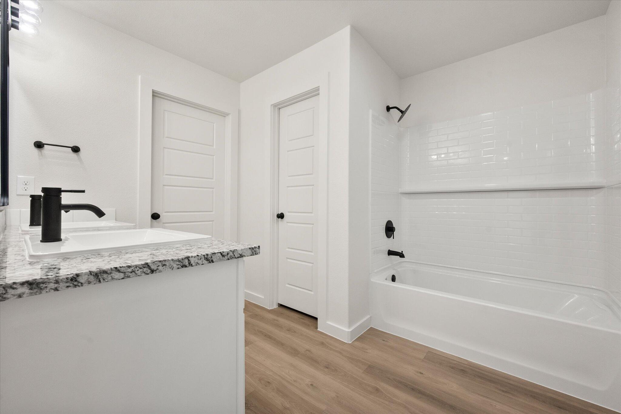 3114 138th Place Lubbock, TX 79423 - Photo 14 of 21 a bathroom with a granite countertop sink and a bathtub