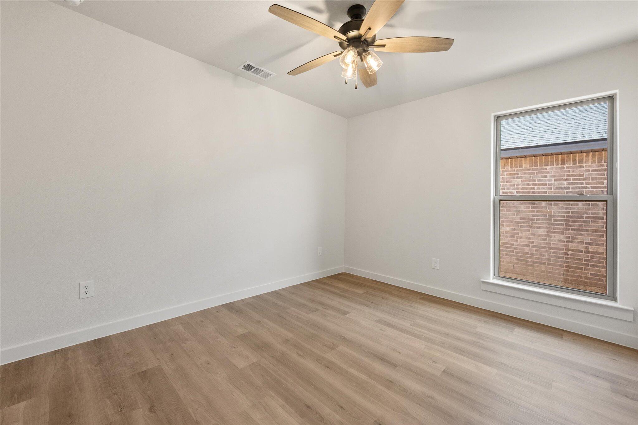 3114 138th Place Lubbock, TX 79423 - Photo 17 of 21 an empty room with a window and ceiling fan