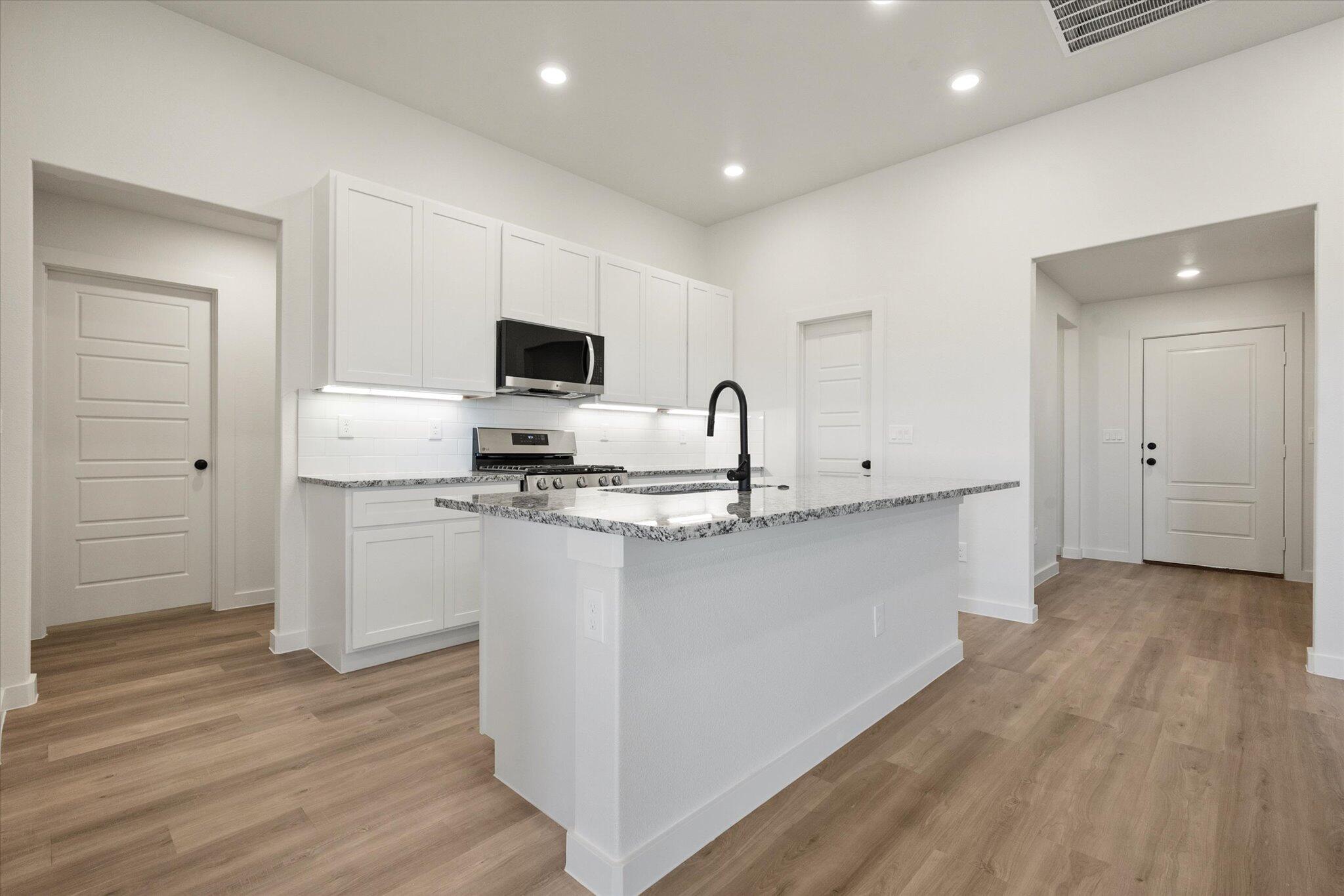 3114 138th Place Lubbock, TX 79423 - Photo 7 of 21 a kitchen with stainless steel appliances a refrigerator sink and white cabinets