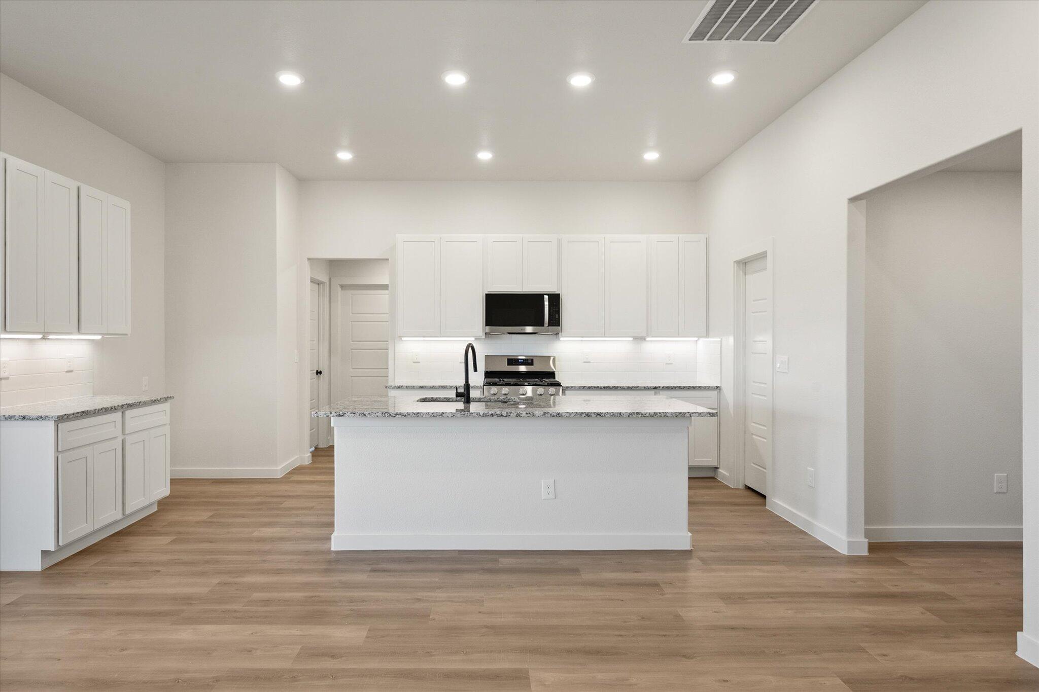 3114 138th Place Lubbock, TX 79423 - Photo 8 of 21 a view of kitchen with microwave stove refrigerator and cabinets