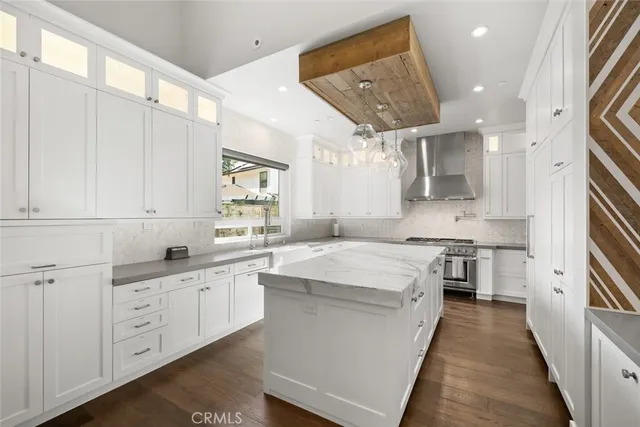a kitchen that has a stove and a wooden floor