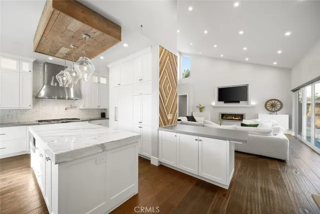 a large white kitchen with a large counter top and stainless steel appliances