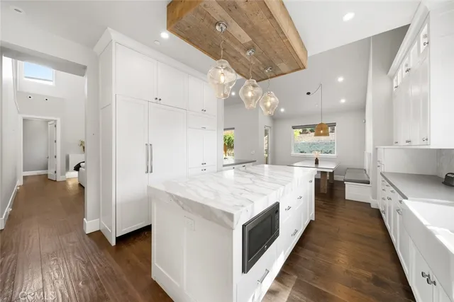 a large kitchen with stainless steel appliances a large center island attached withe living room