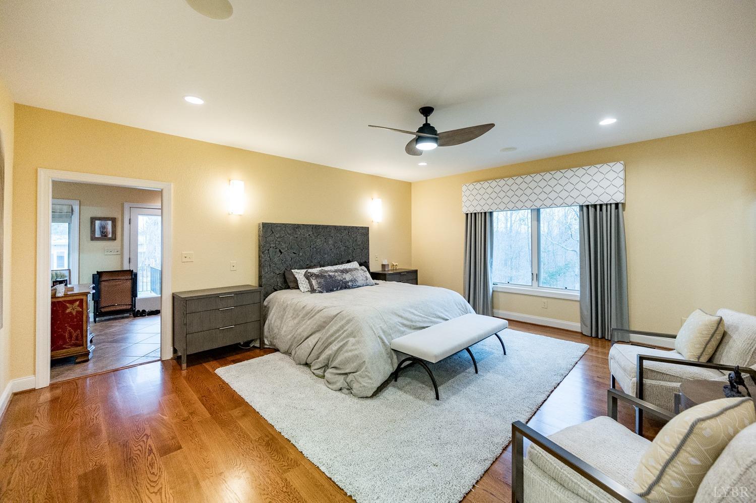 657 Cherry Hill Road Amherst, VA 24521 - Photo 33 of 91 a spacious bedroom with a bed a couch and a chandelier
