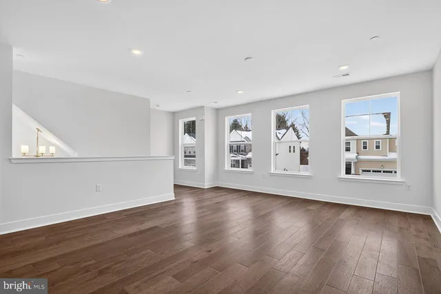an empty room with wooden floor and window