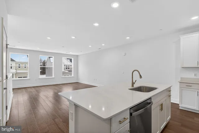 a kitchen with stainless steel appliances granite countertop a sink and dishwasher with wooden floor