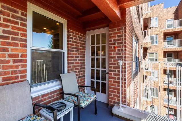 a view of a chair and table in the back yard of a building