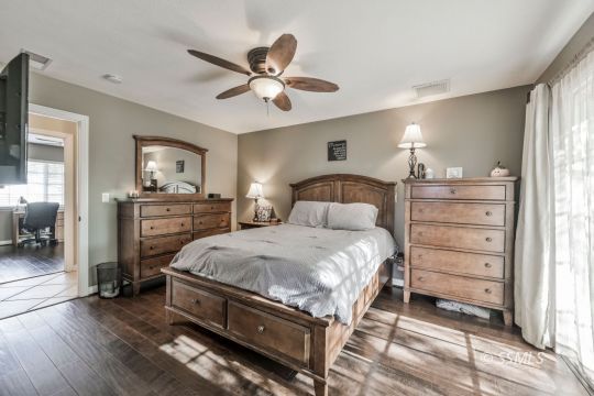 1267 North Erwin Street Ridgecrest, CA 93555 - Photo 18 of 35 a bedroom with a bed and a chandelier