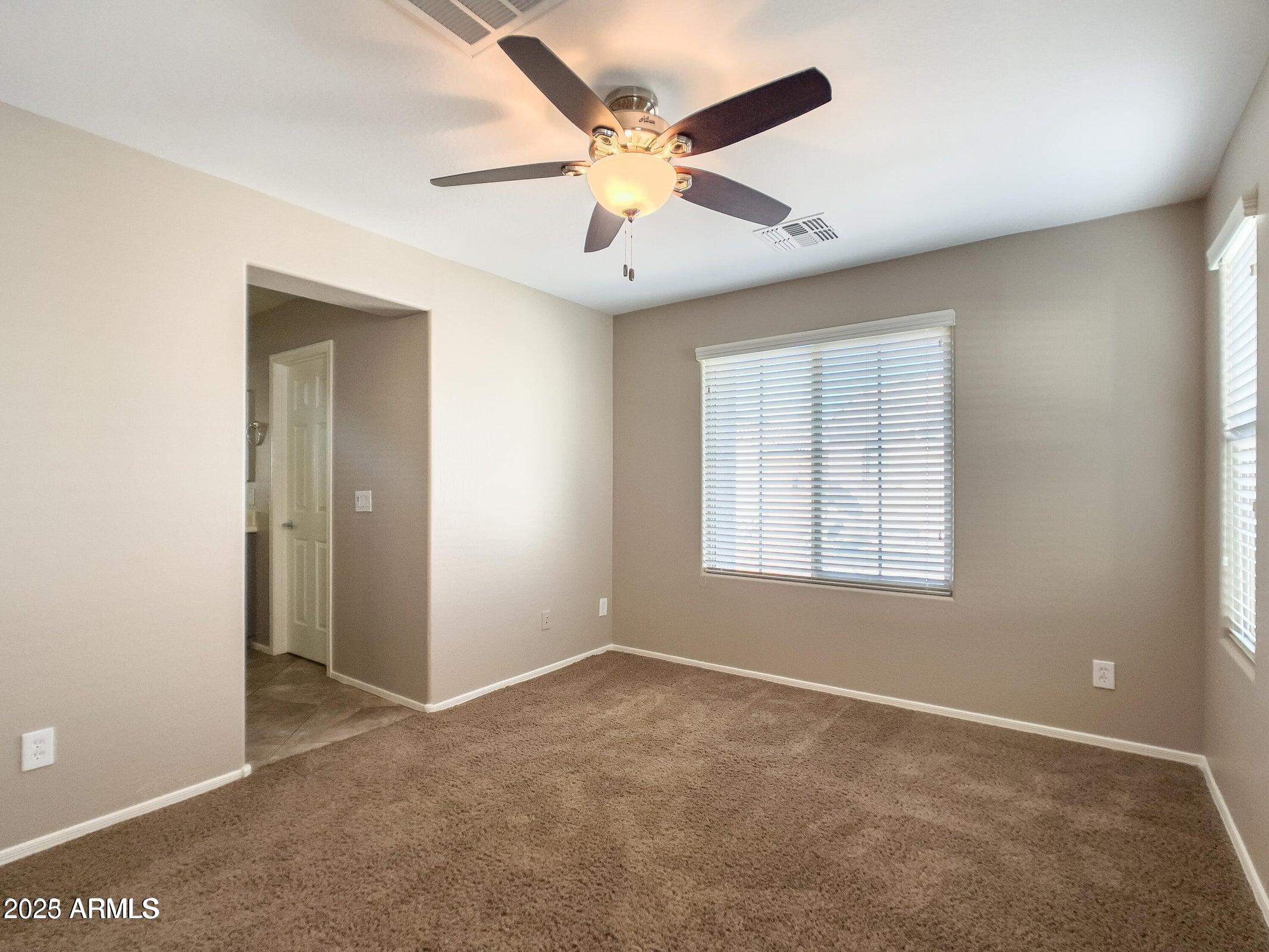 1958 West Busoni Place Phoenix, AZ 85023 - Photo 11 of 42 an empty room with ceiling fan and window