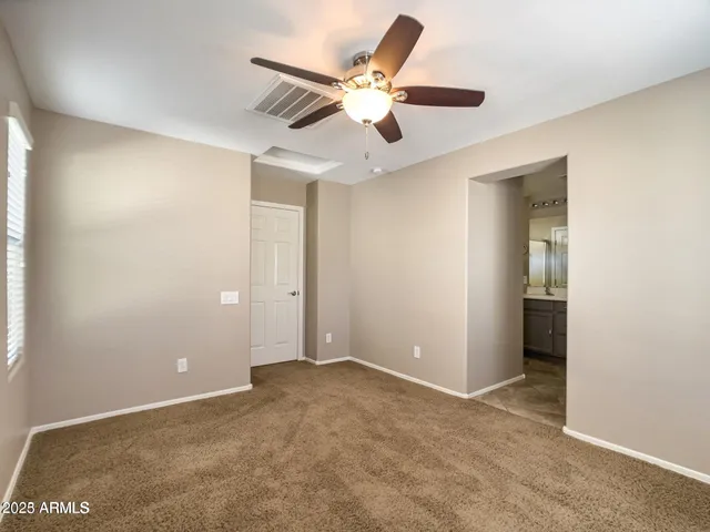 an empty room with a ceiling fan and a window