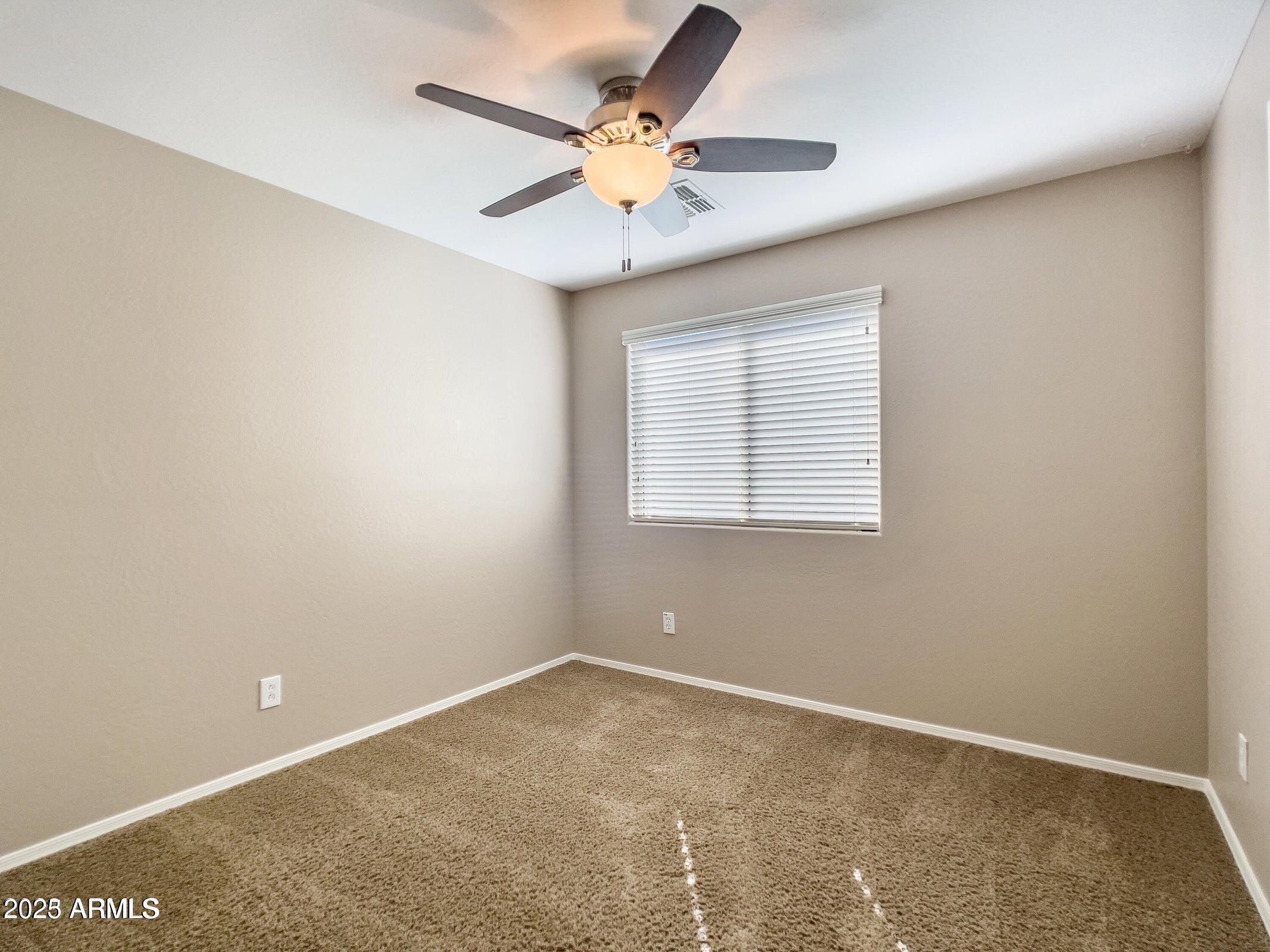 1958 West Busoni Place Phoenix, AZ 85023 - Photo 21 of 42 an empty room with a ceiling fan and a window