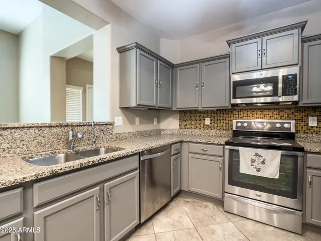 a kitchen with stainless steel appliances granite countertop a refrigerator and a stove top oven