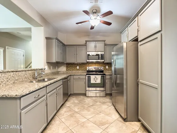 a kitchen with a stove a sink cabinets and appliances