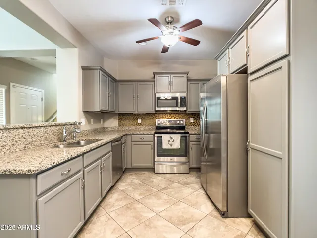 a kitchen with a stove a sink cabinets and appliances