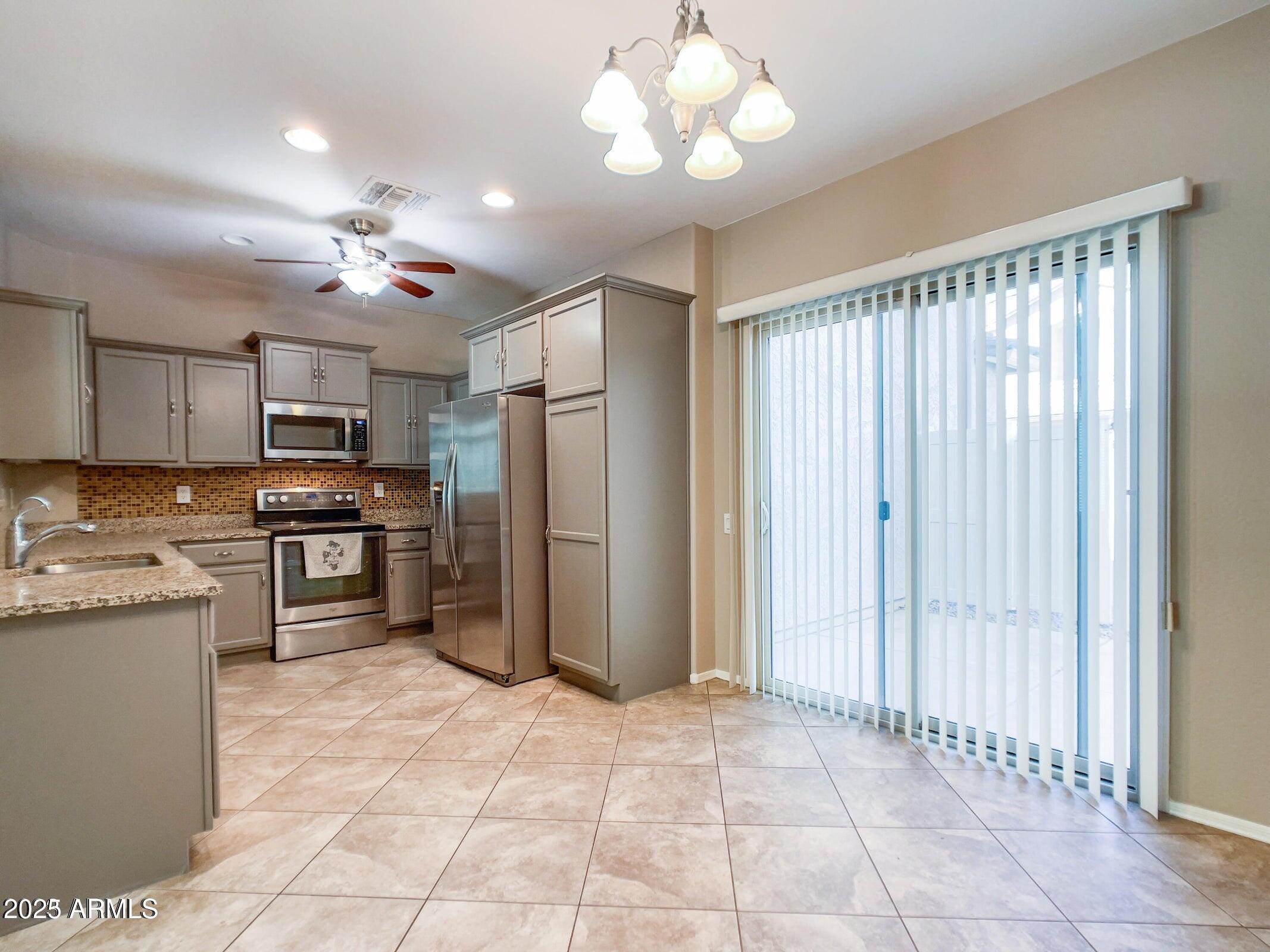 1958 West Busoni Place Phoenix, AZ 85023 - Photo 28 of 42 a kitchen with stainless steel appliances granite countertop a refrigerator and a stove top oven