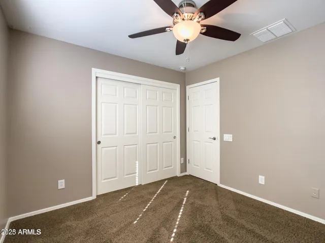 an empty room with a window and a ceiling fan