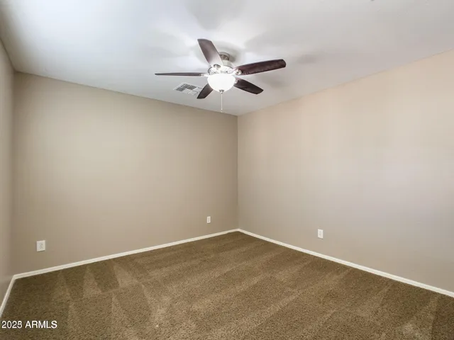 an empty room with a ceiling fan and a window