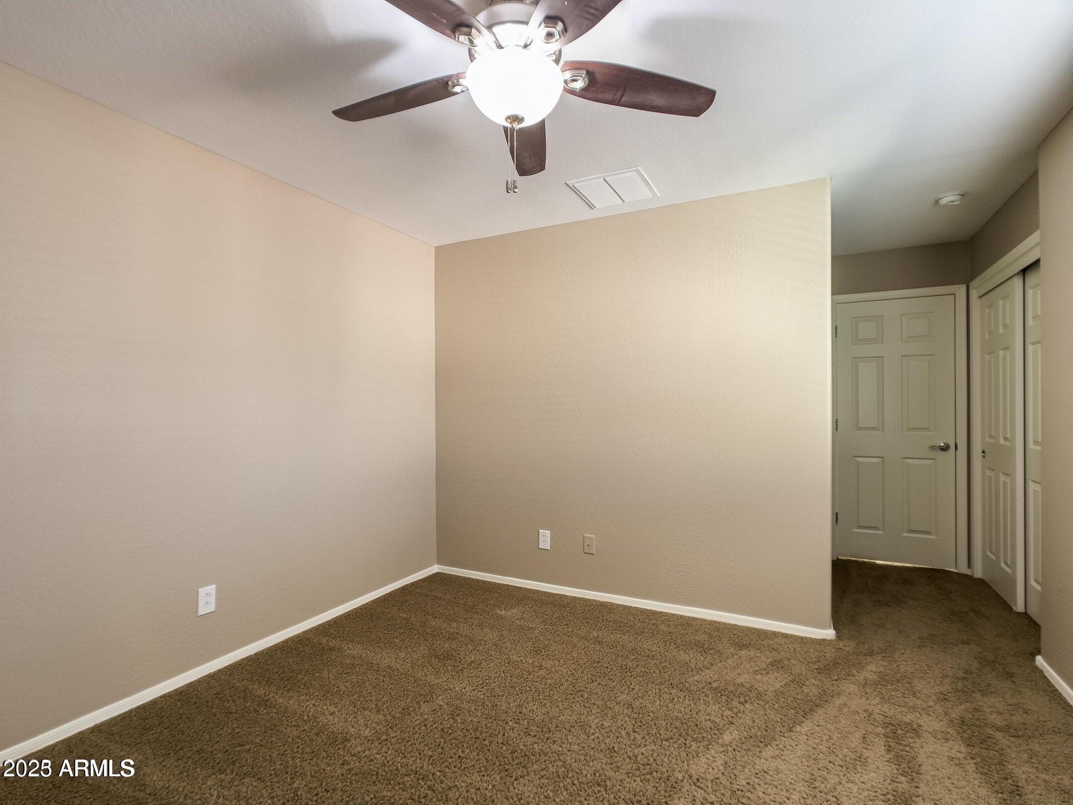 1958 West Busoni Place Phoenix, AZ 85023 - Photo 10 of 42 an empty room with a ceiling fan and a window