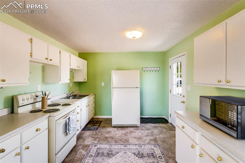 13490 South Lauppe Road Yoder, CO 80864 - Photo 22 of 45 a kitchen with a sink stove and cabinets