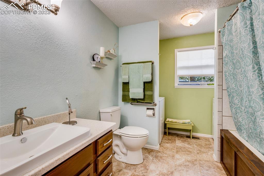 13490 South Lauppe Road Yoder, CO 80864 - Photo 9 of 45 a bathroom with a granite countertop toilet a sink and a mirror