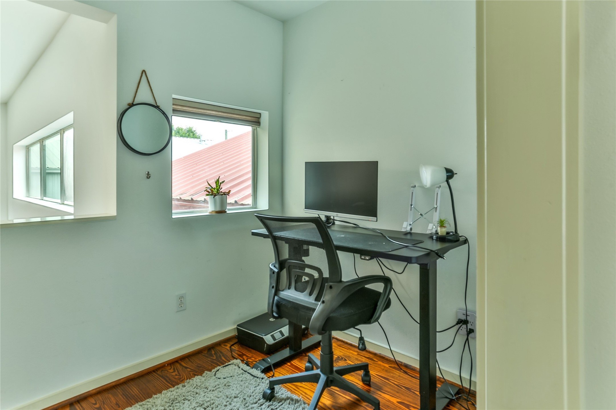 2918 Commerce Street Houston, TX 77003 - Photo 7 of 18 a view of a workspace room with wooden floor and windows