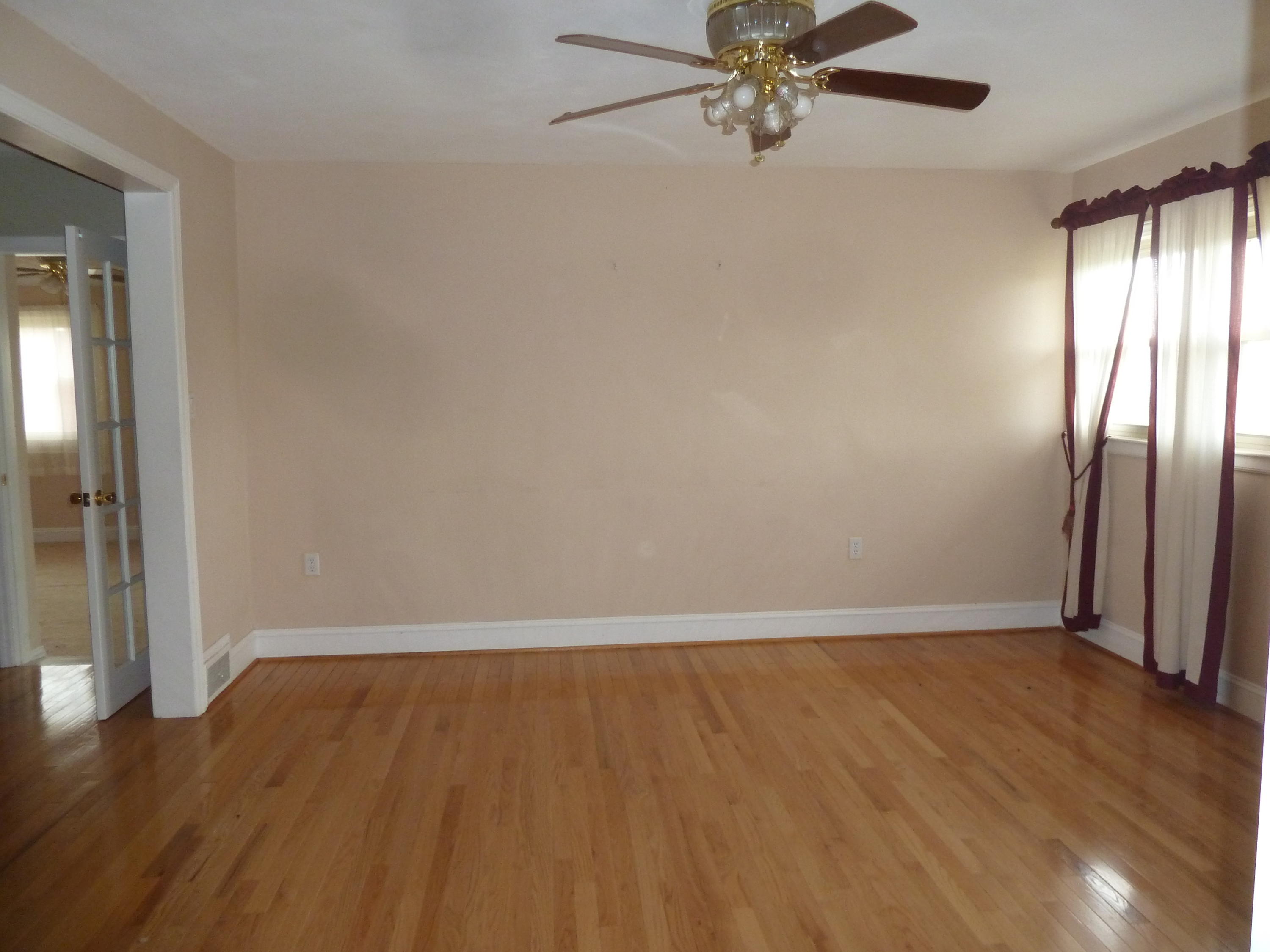 13692 West Gretna Road Sandy Level, VA 24161 - Photo 12 of 58 an empty room with wooden floor fan and windows