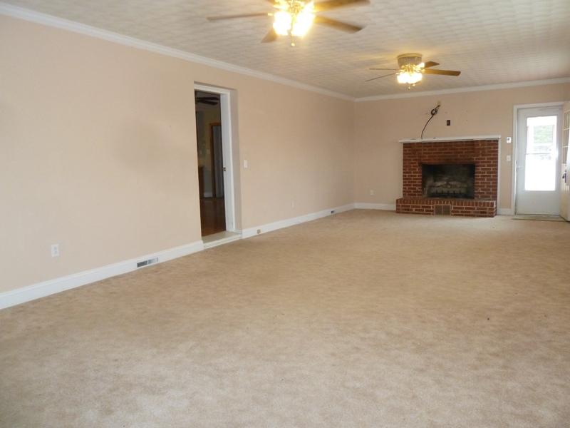 13692 West Gretna Road Sandy Level, VA 24161 - Photo 34 of 58 an empty room with a fireplace and fan