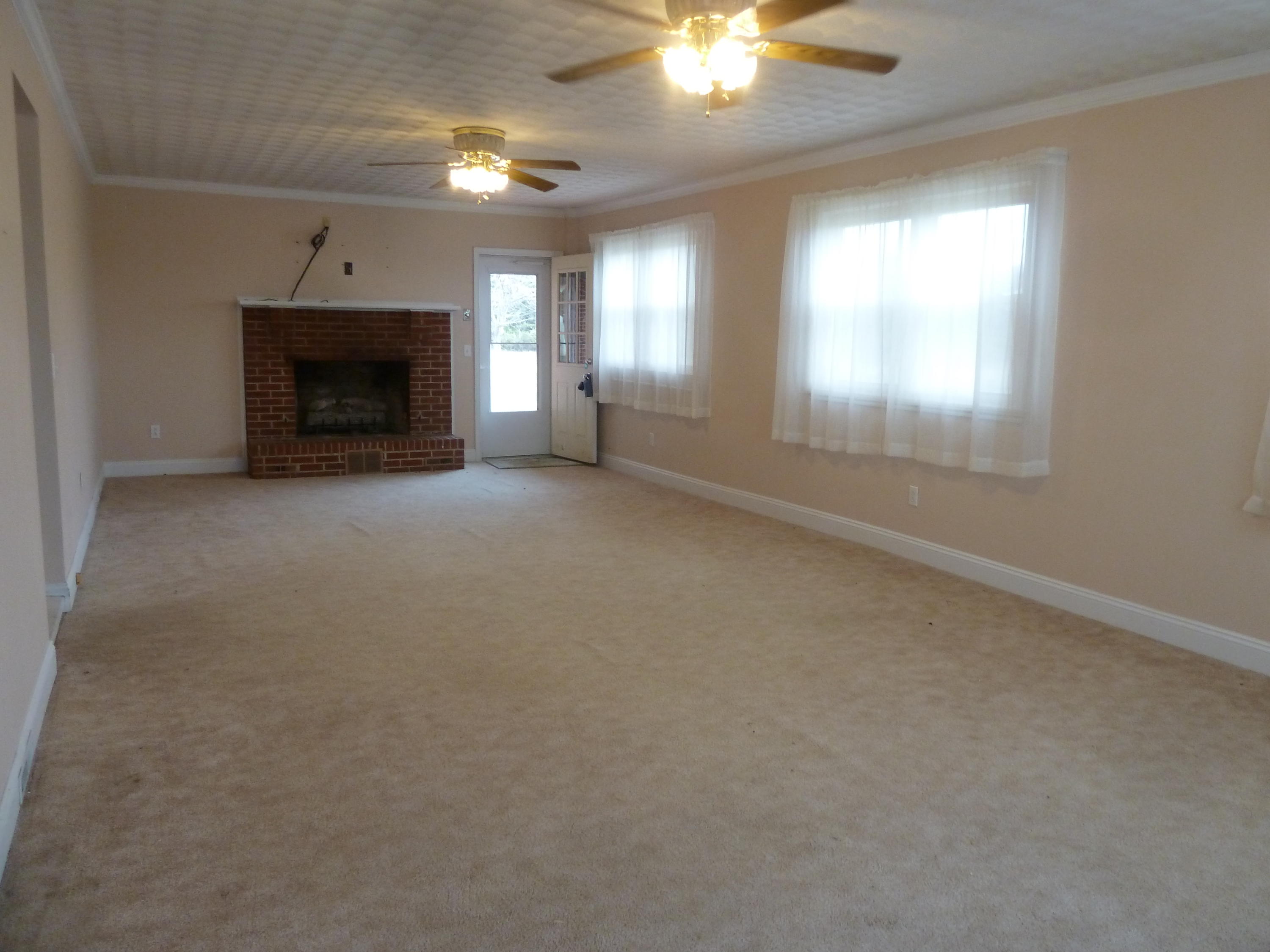 13692 West Gretna Road Sandy Level, VA 24161 - Photo 6 of 58 an empty room with windows and fireplace