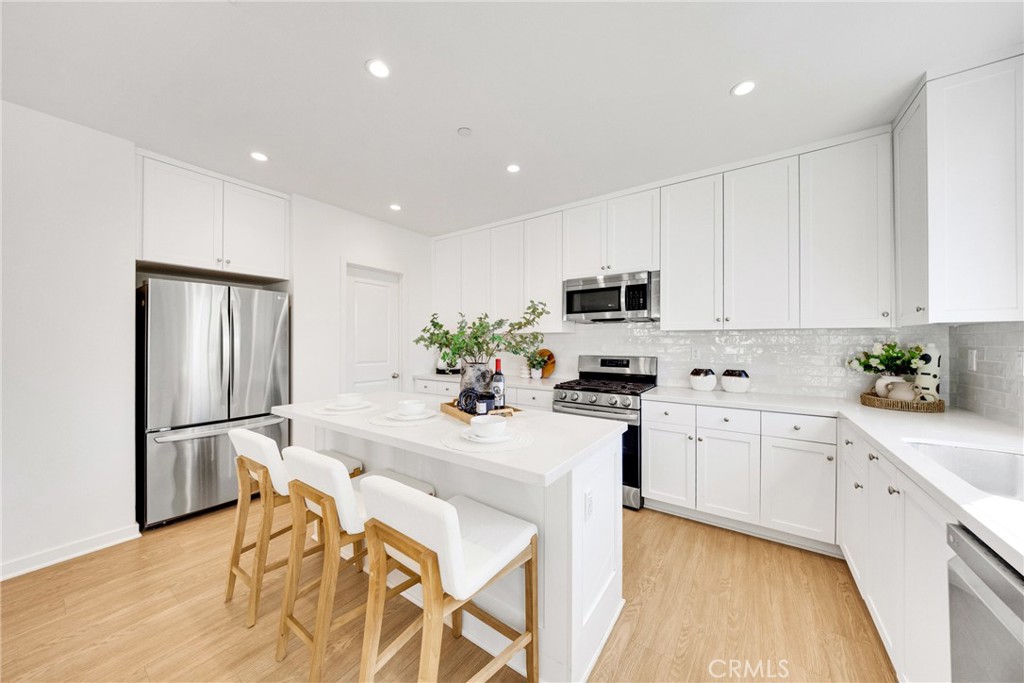 716 Spring Garden Irvine, CA 92618 - Photo 20 of 44 a kitchen with stainless steel appliances granite countertop a refrigerator sink and white cabinets