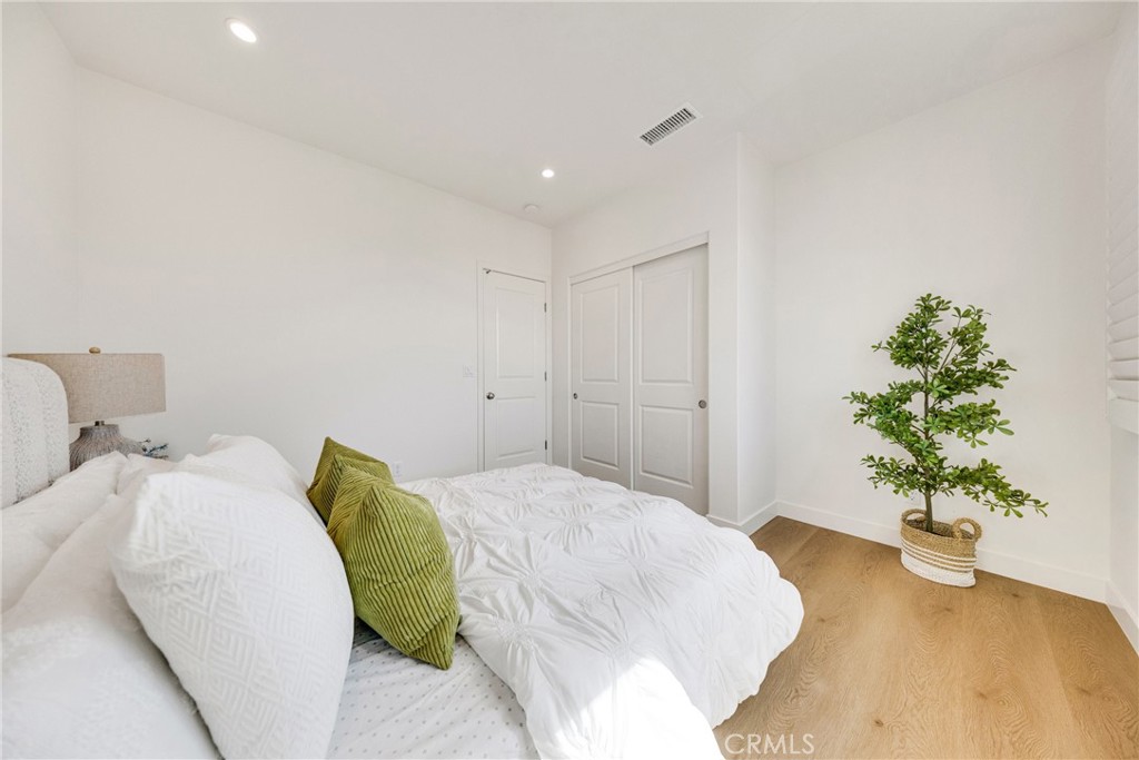 716 Spring Garden Irvine, CA 92618 - Photo 32 of 44 a spacious bedroom with a bed and a potted plant