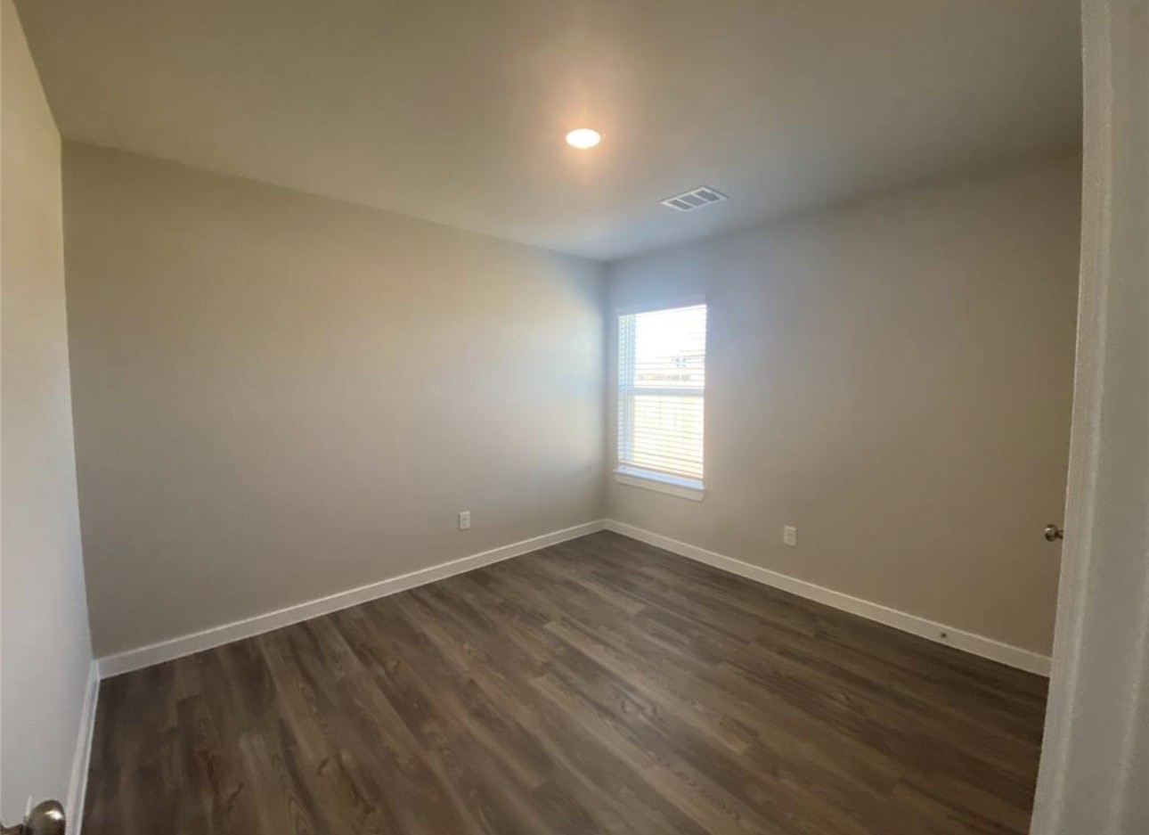 3119 Spanish Oak Lane Rosenberg, TX 77471 - Photo 15 of 18 a view of an empty room with wooden floor and a window