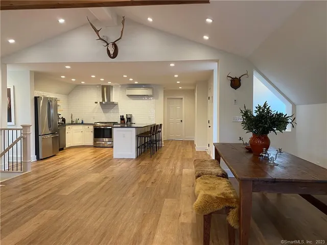 a kitchen with stainless steel appliances kitchen island granite countertop a sink a stove and a refrigerator