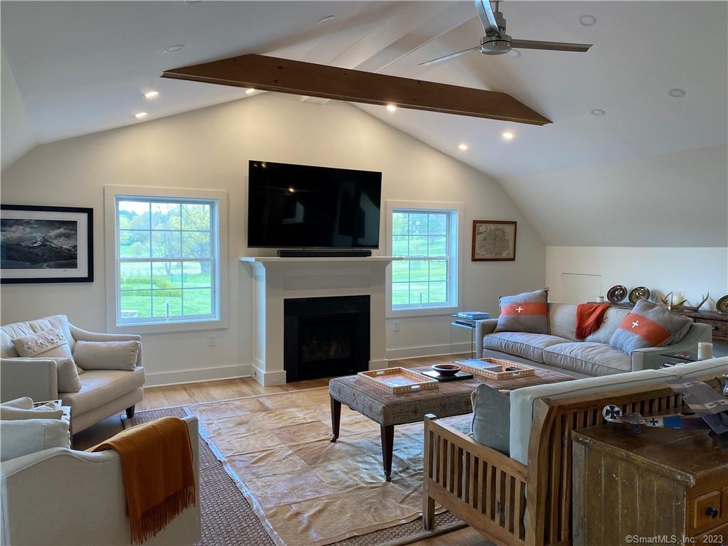 55 Still Meadow Road Sharon, CT 06069 - Photo 15 of 24 a living room with furniture a flat screen tv and a fireplace