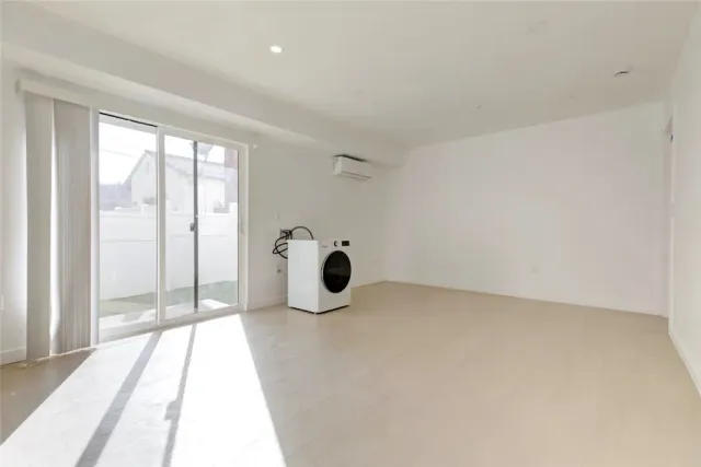 a view of a big room with wooden floor and windows