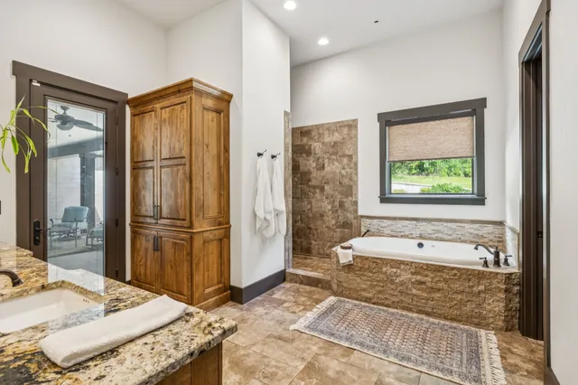 a bathroom with a granite countertop sink and a large mirror