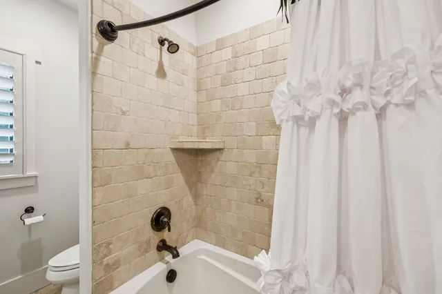 a spacious bedroom with a bed a chandelier and a window